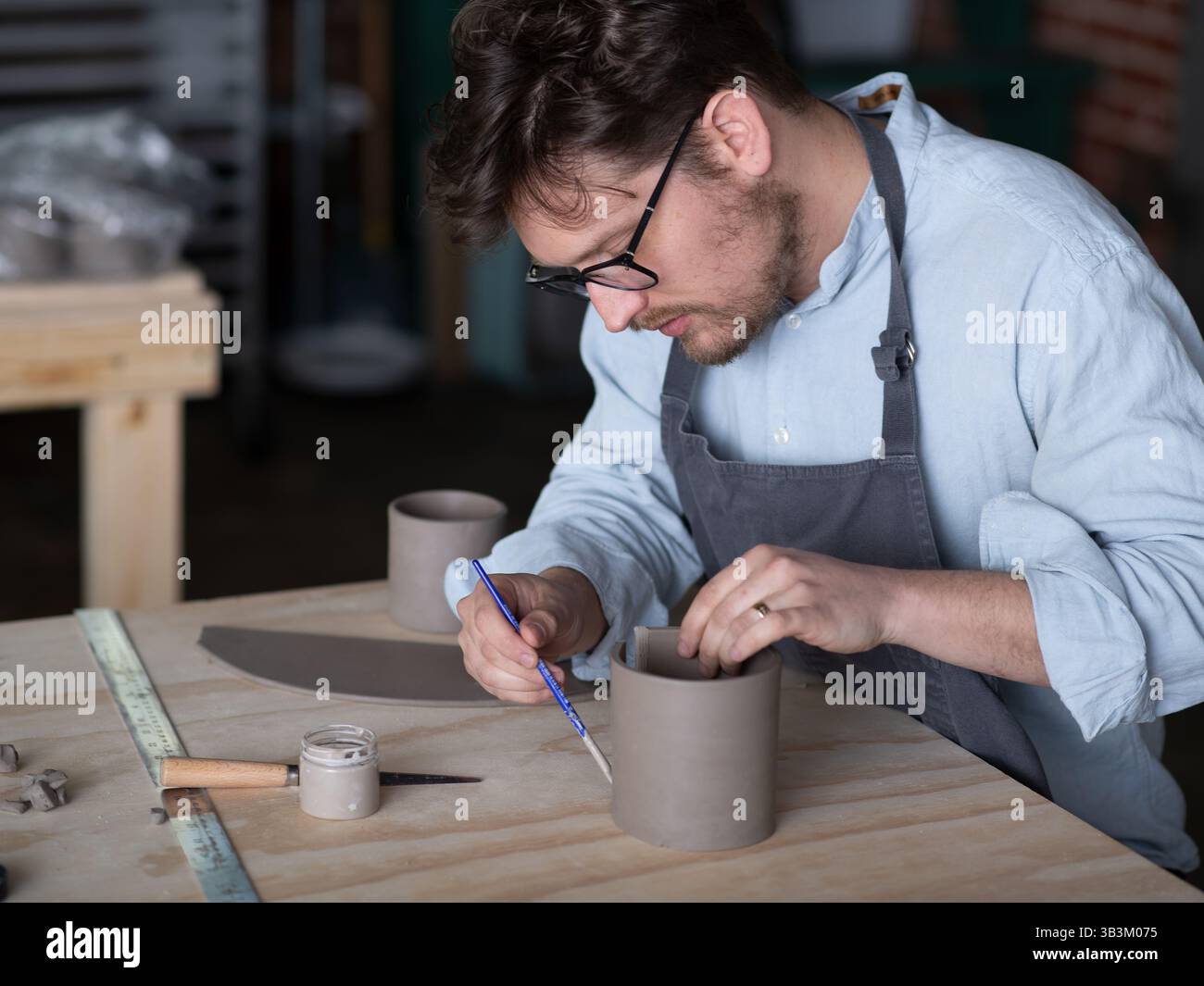 Ceramic artists working in pottery studio Stock Photo - Alamy