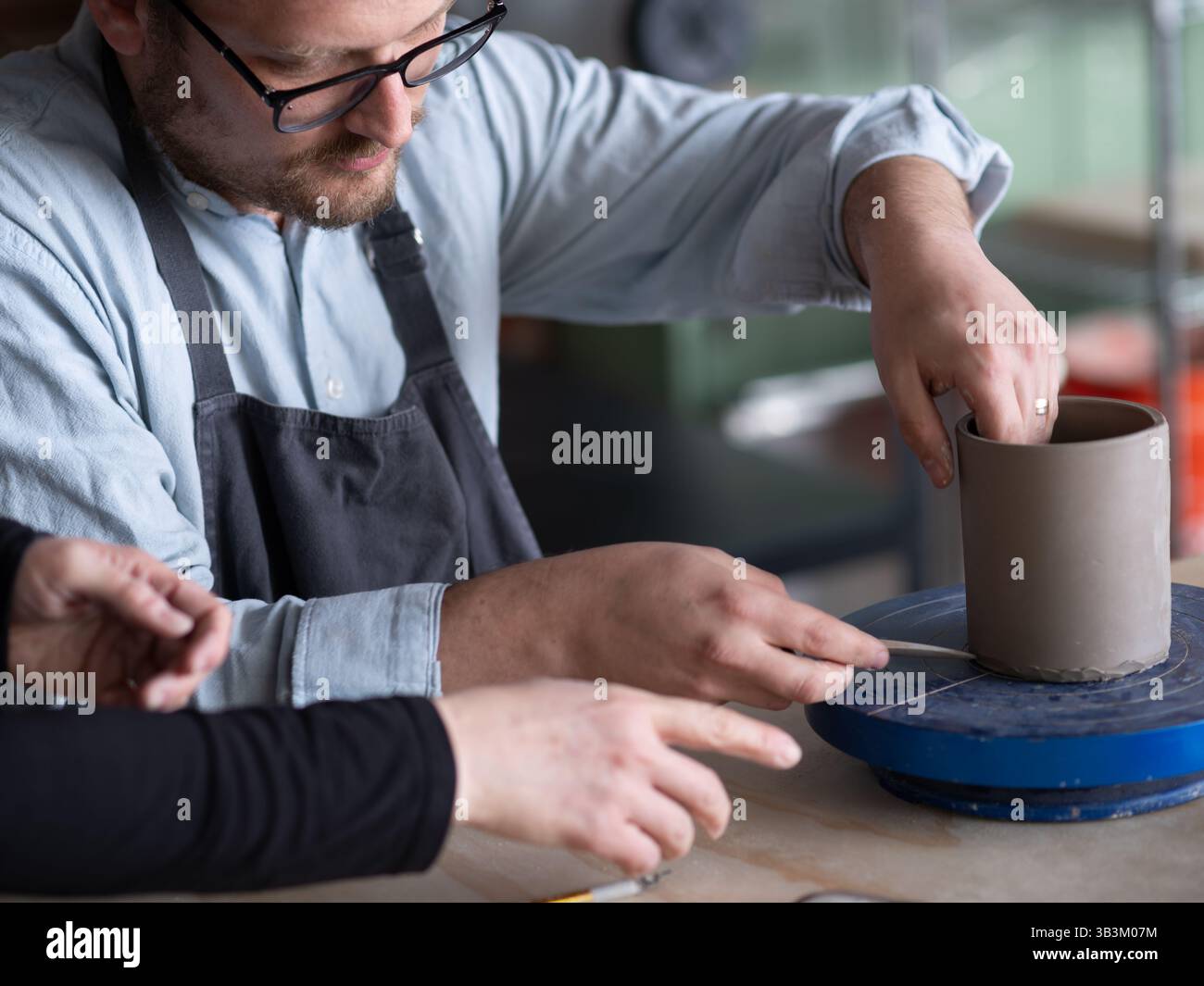 Ceramic artists working in pottery studio Stock Photo - Alamy