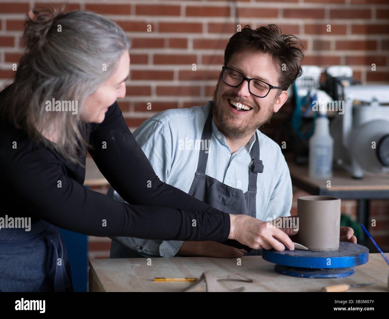 Ceramic artists working in pottery studio Stock Photo - Alamy