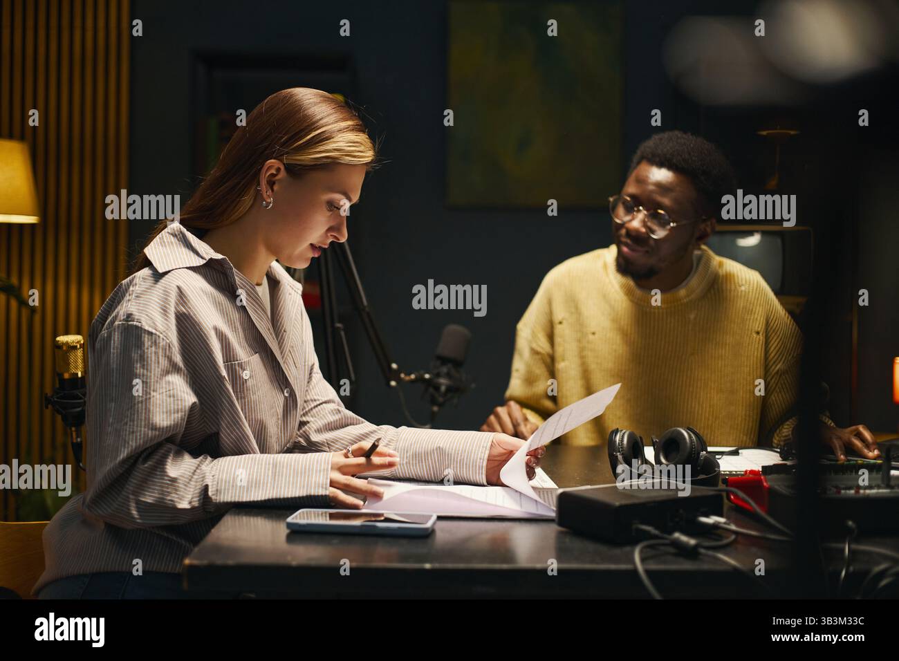 Colleagues Reading Text Before Podcast Stock Photo