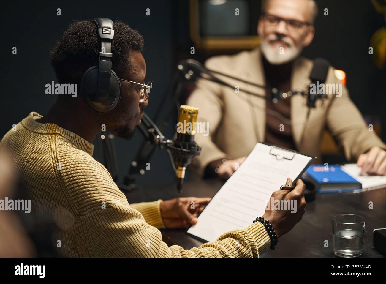 Man Reading Plan Before Podcast Stock Photo