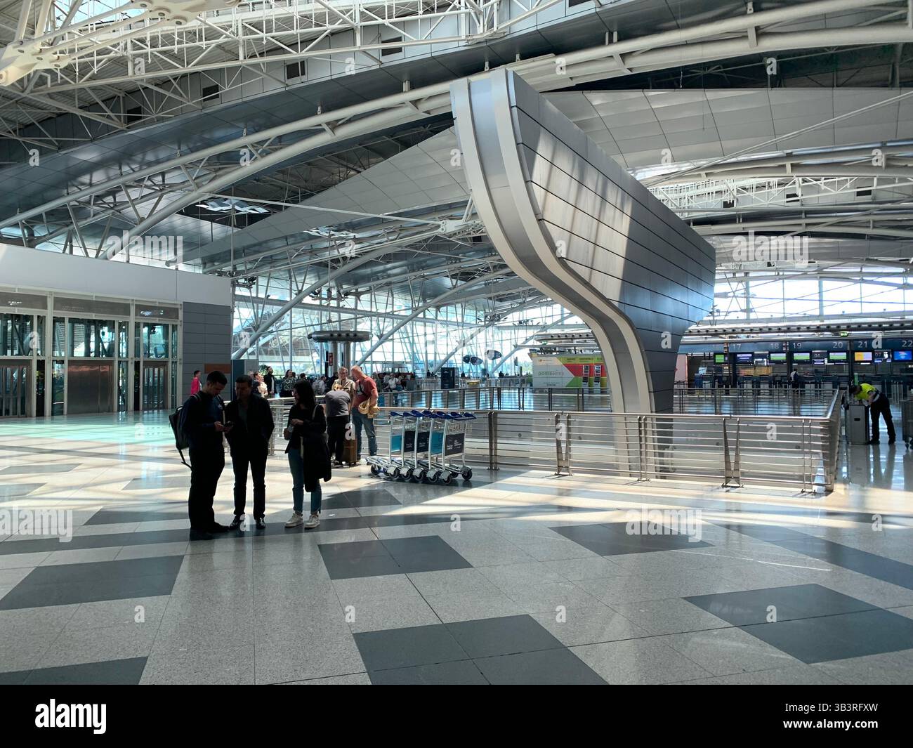 Porto Airport Portugal people waiting for a flight lights light floor tiles large space metal frame work que going home check-in desk desks bags leave - Smartphone Captured Stock Image
