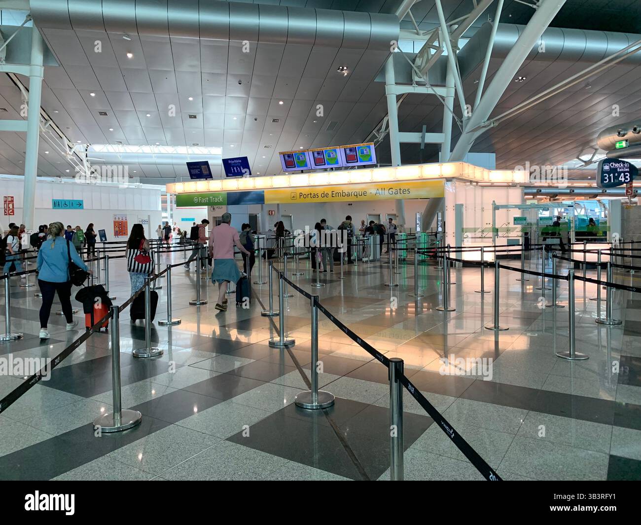 Porto Airport Portugal people waiting for a flight lights light floor tiles large space metal frame work que going home check-in desk desks bags leave - Smartphone Captured Stock Image