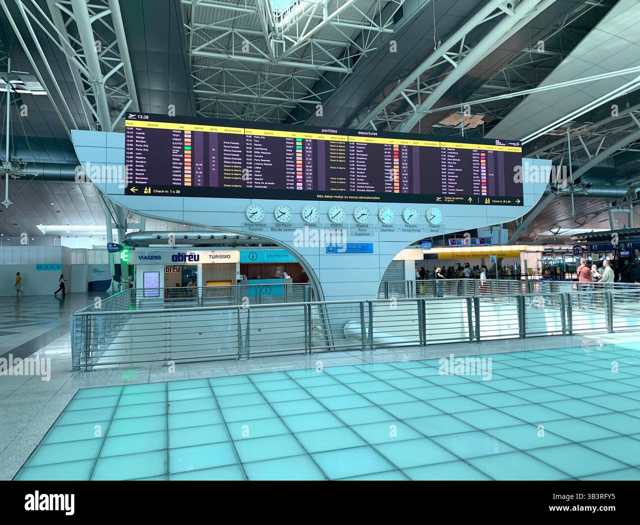 Porto Airport Portugal people waiting for a flight lights light floor tiles large space metal frame work que going home check-in desk desks bags leave - Smartphone Captured Stock Image