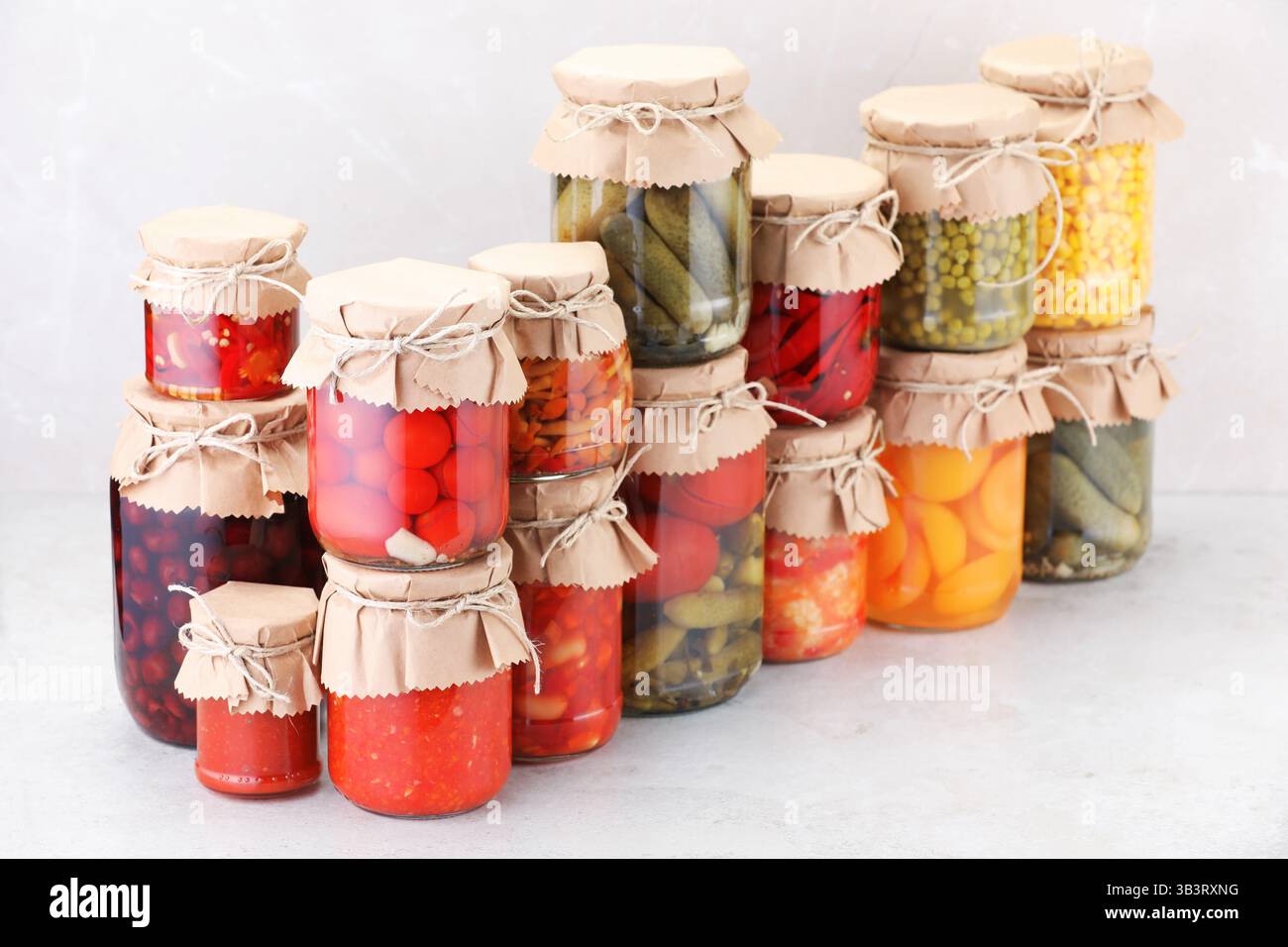 Many jars with different pickled products on light table Stock Photo