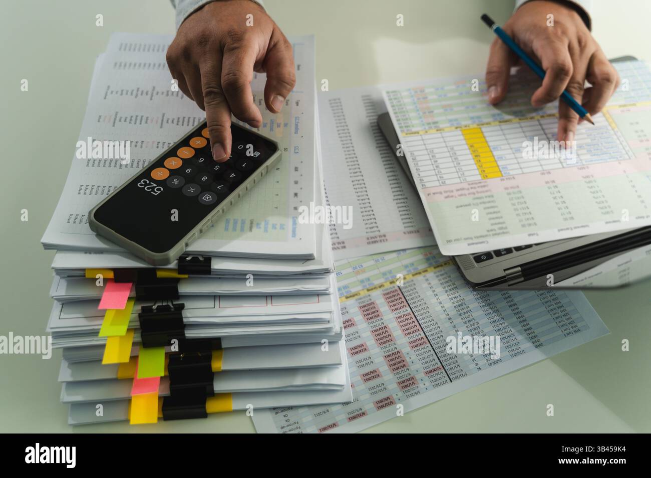 man accountant working on desk using calculator calculate while working analytic Accounting Stock Photo