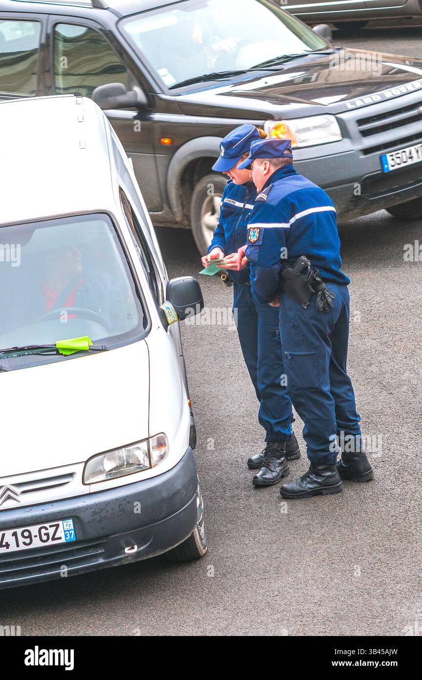 Two gendarmes checking driver's documents at routine traffic stop - France. Stock Photo