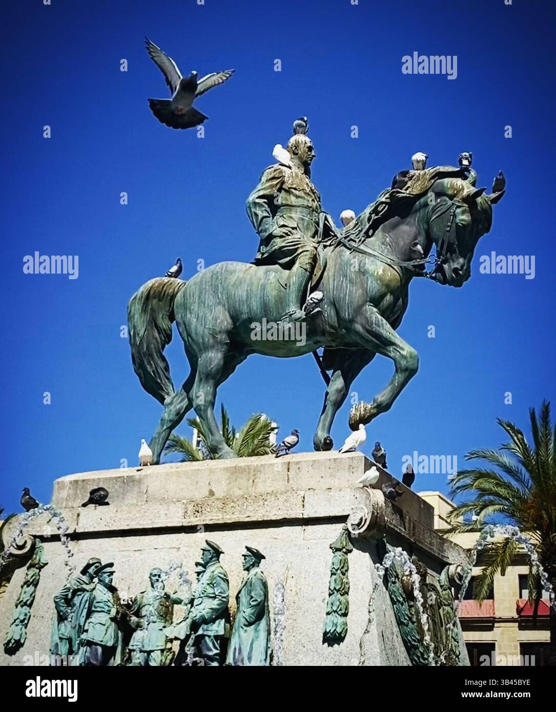 A pigeon flies near the monument of Miguel Primo de Rivera in the Plaza del Arenal square in Jerez de la Frontera, Cadiz, Andalusia, Spain - Smartphone Captured Stock Image