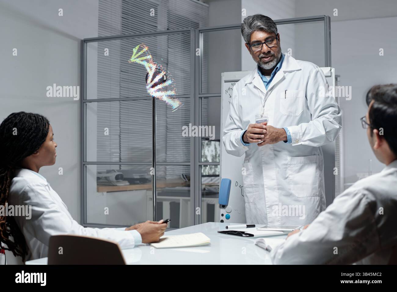 Male scientist explaining genetic code to colleagues in lab setting ...