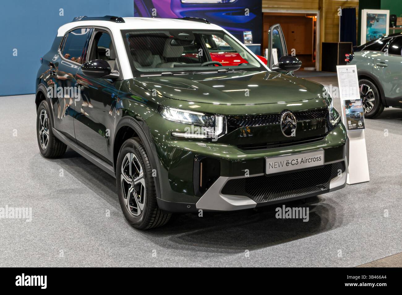 Riga, Latvia - April 25, 2025: A Citroen e-C3 SUV in green with a white roof stands on display at an auto exhibition event Stock Photo