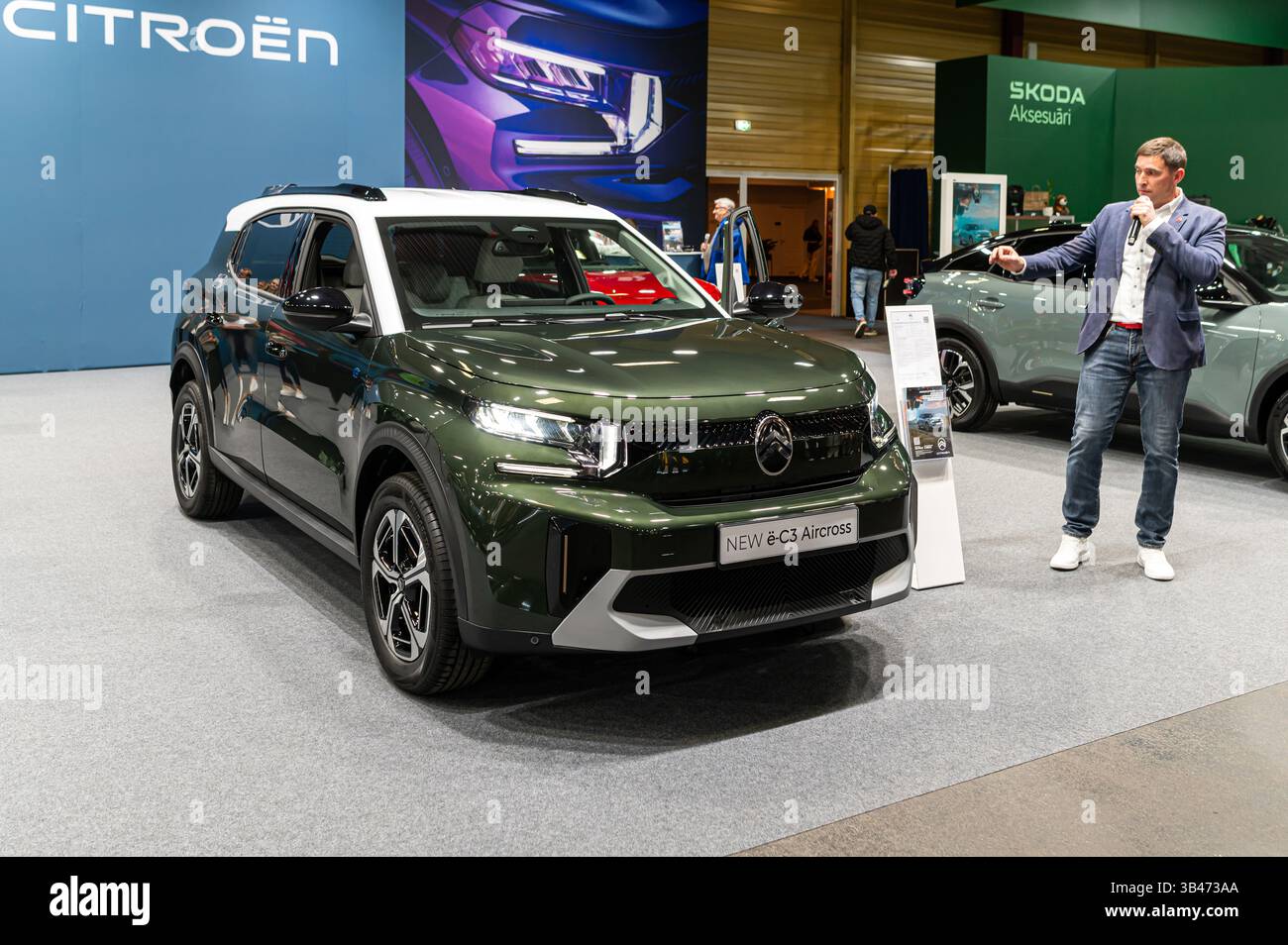 Riga, Latvia - April 25, 2025: A Citroen e-C3 Aircross SUV is showcased at an event, with a speaker explaining its specs. Stock Photo