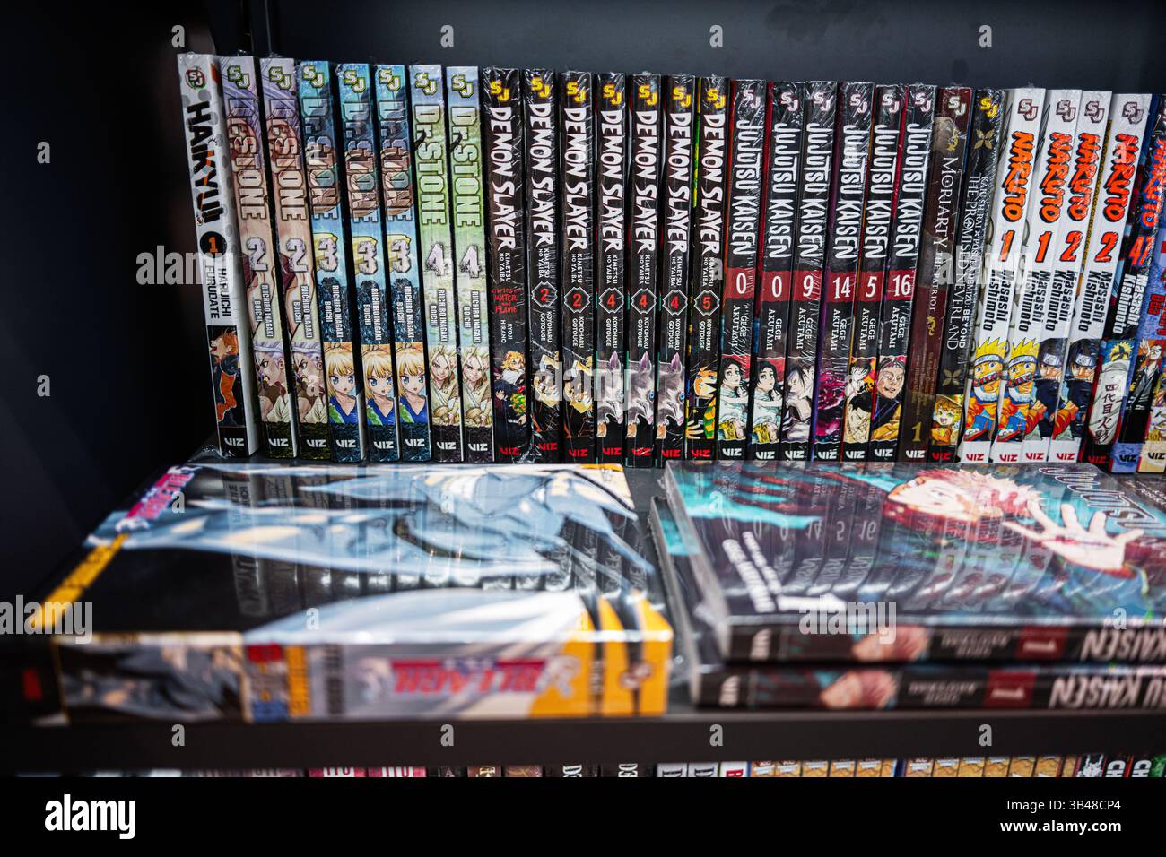 Ivano-Frankivsk, Ukraine - April 29, 2025: A bookshelf stacked with popular manga series featuring fantasy and action narratives. Stock Photo