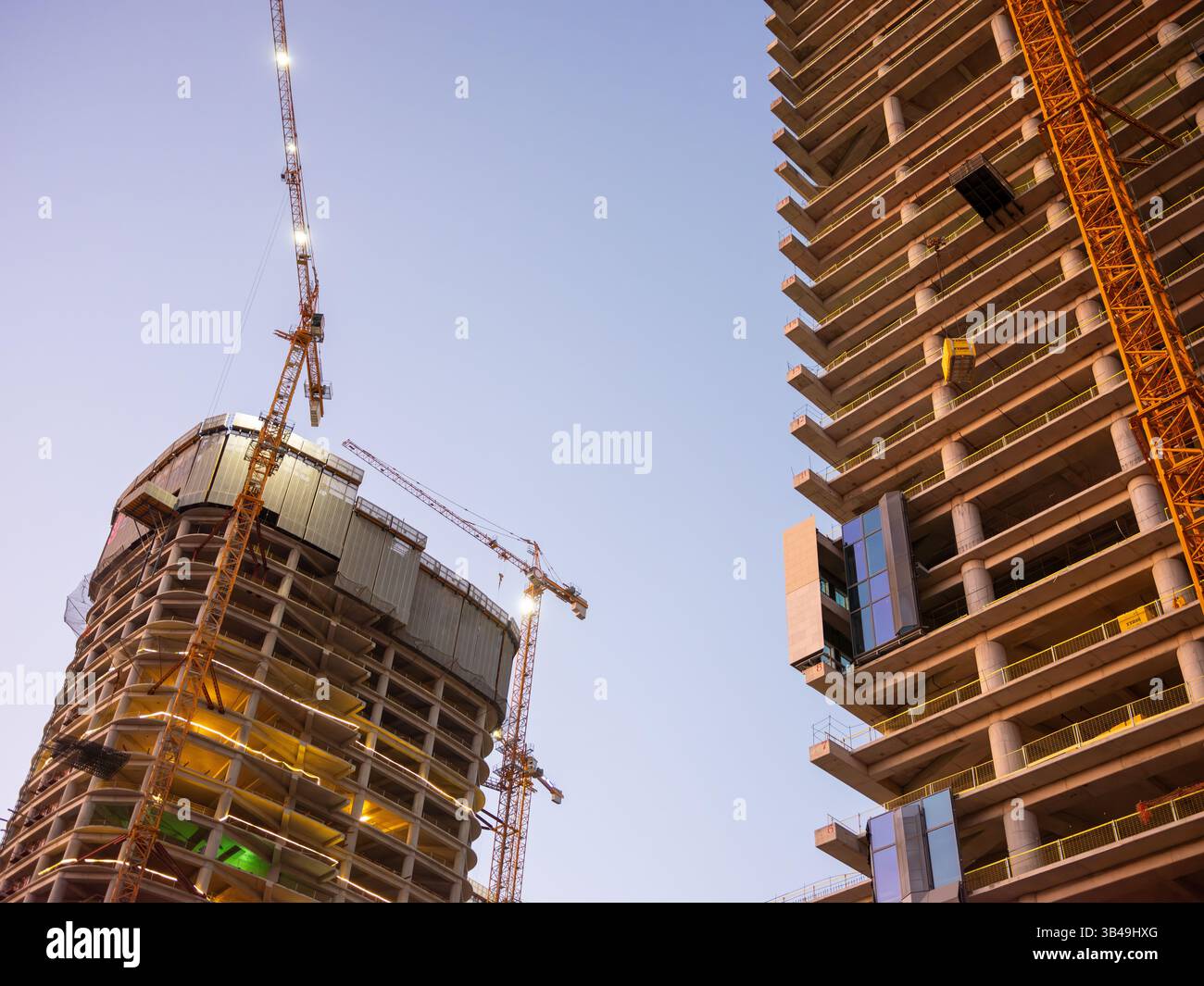 Modern skyscrapers under construction with cranes, symbolizing urban ...