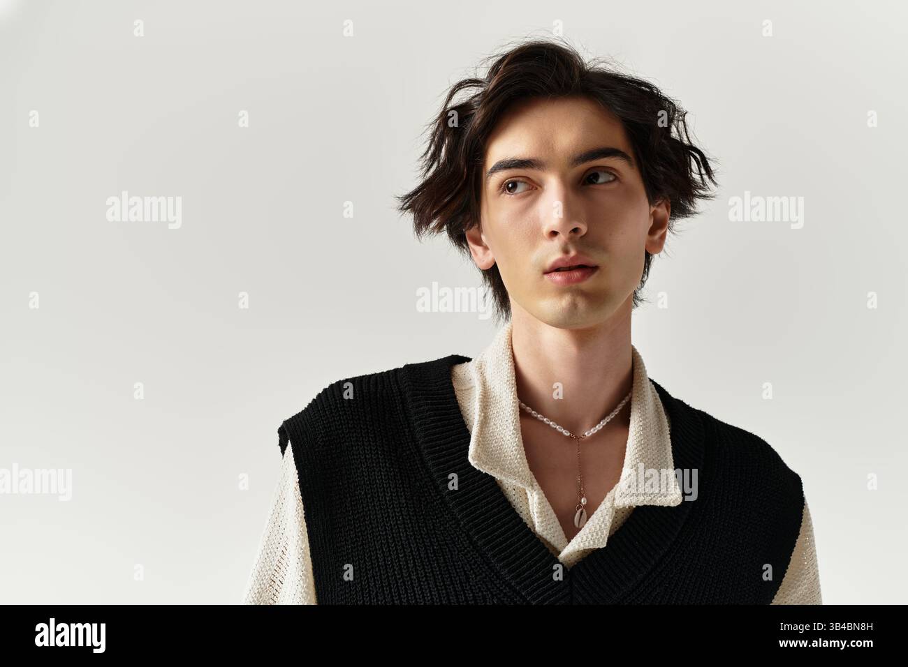 In a contemporary studio, a stylish young man exudes confidence with ...