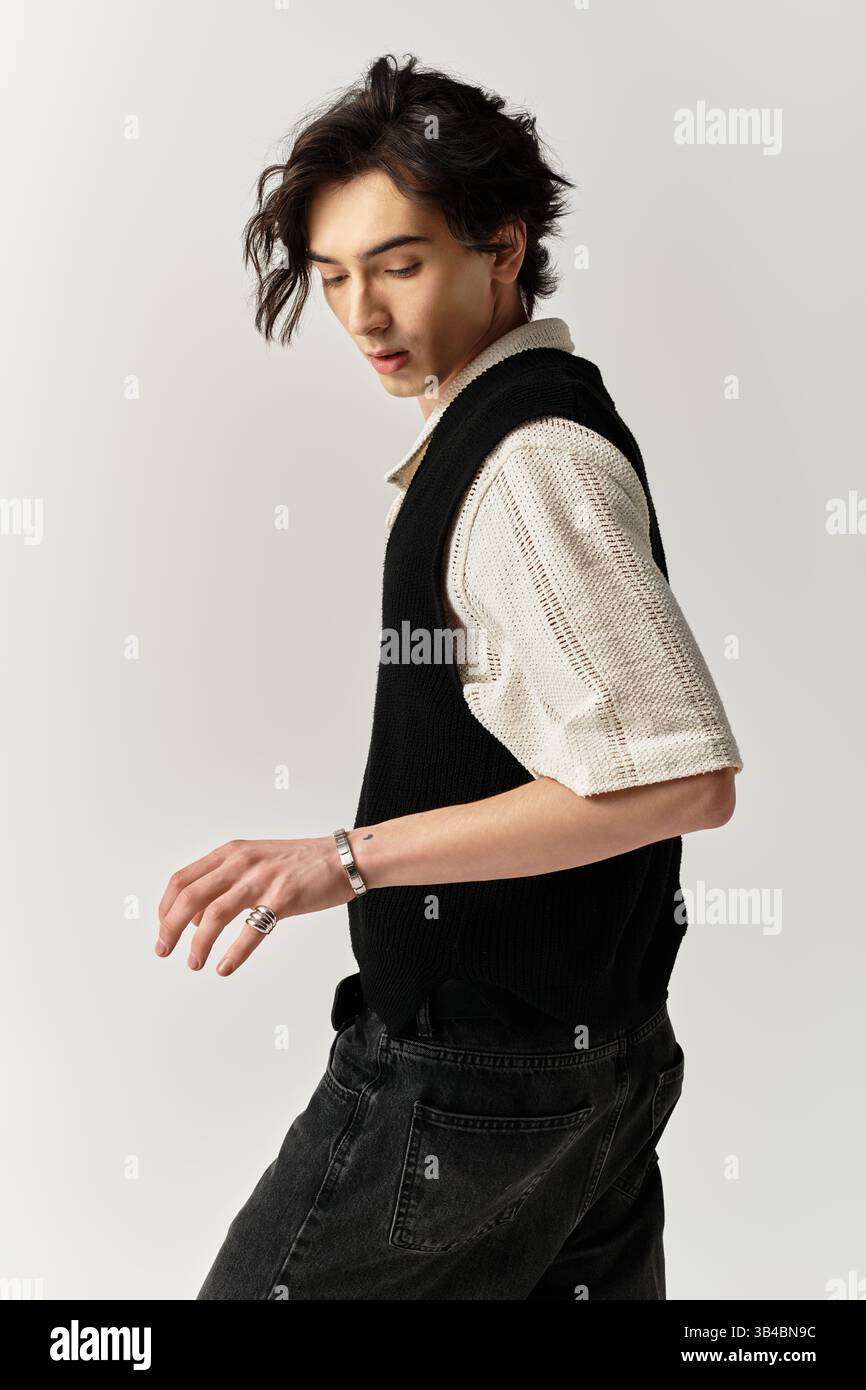 A handsome young man confidently poses, flaunting his trendy outfit in ...