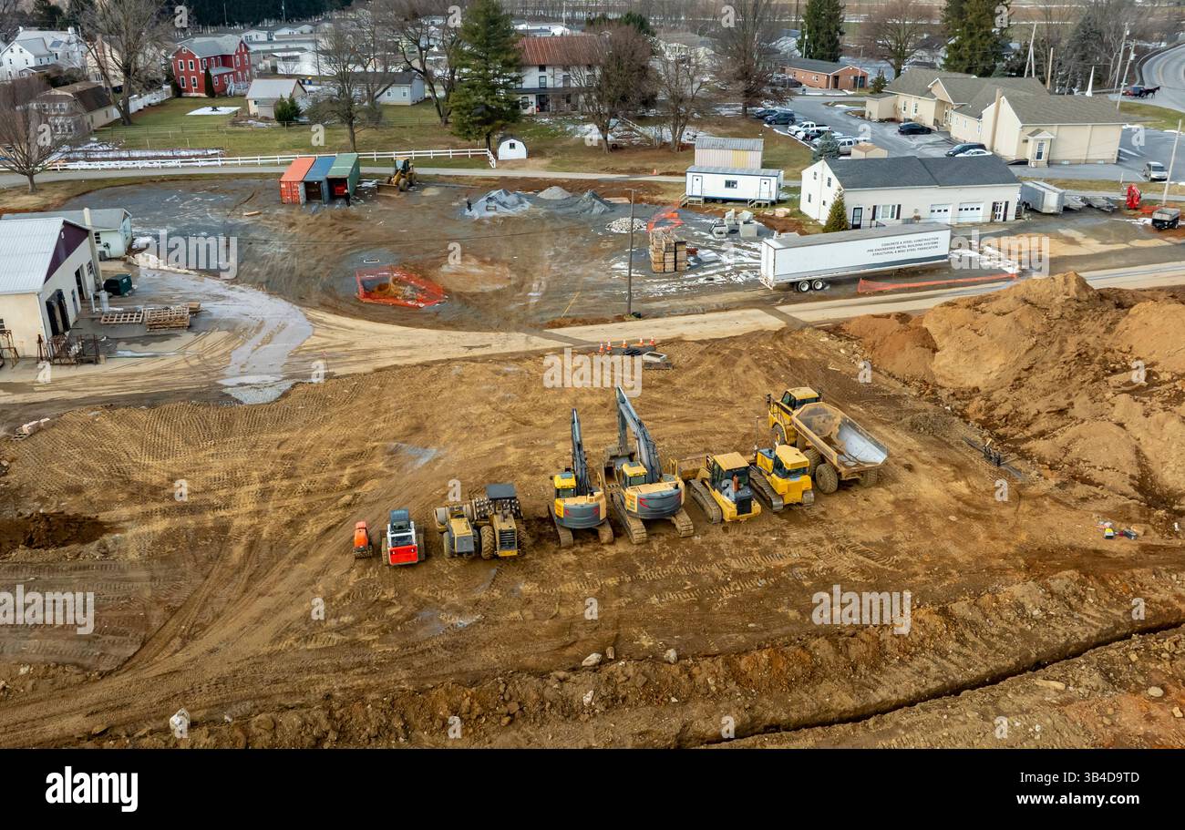 Heavy machinery including excavators and dump trucks is actively ...