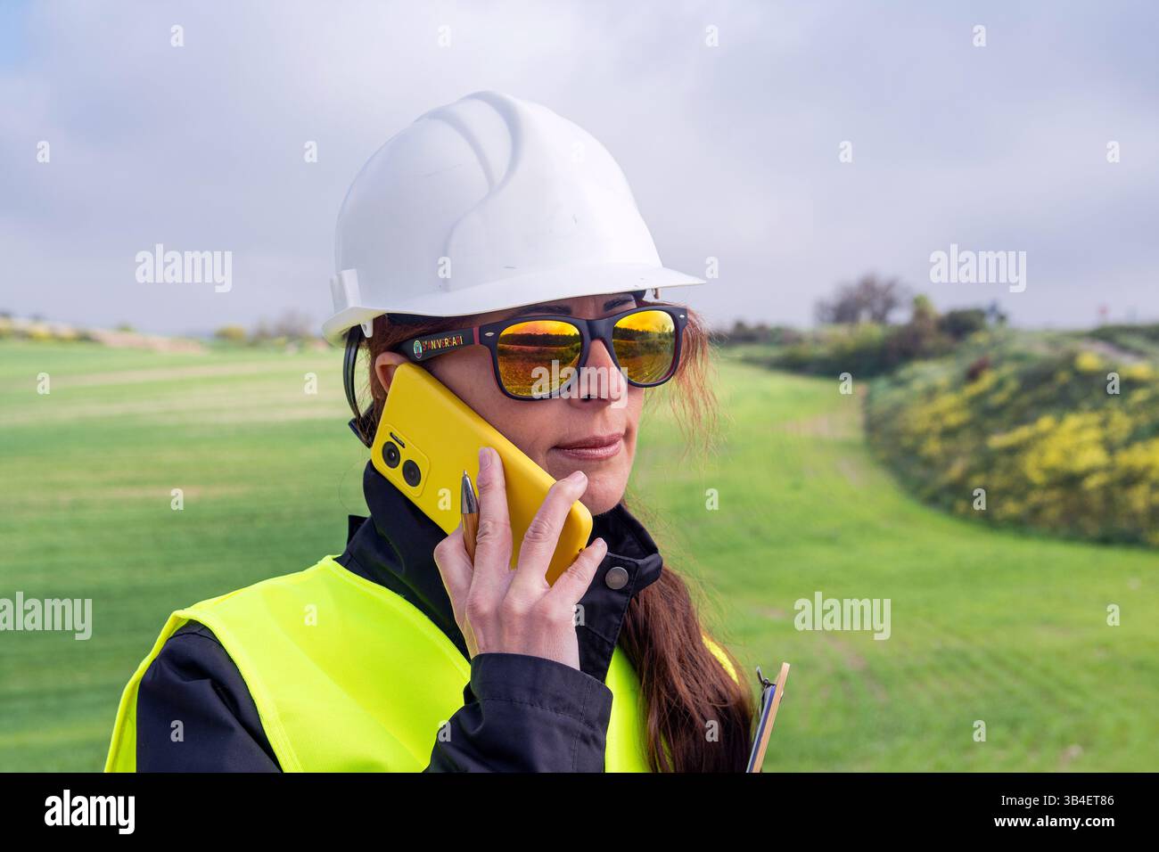 Female engineer using smartphone on renewable energy site Stock Photo