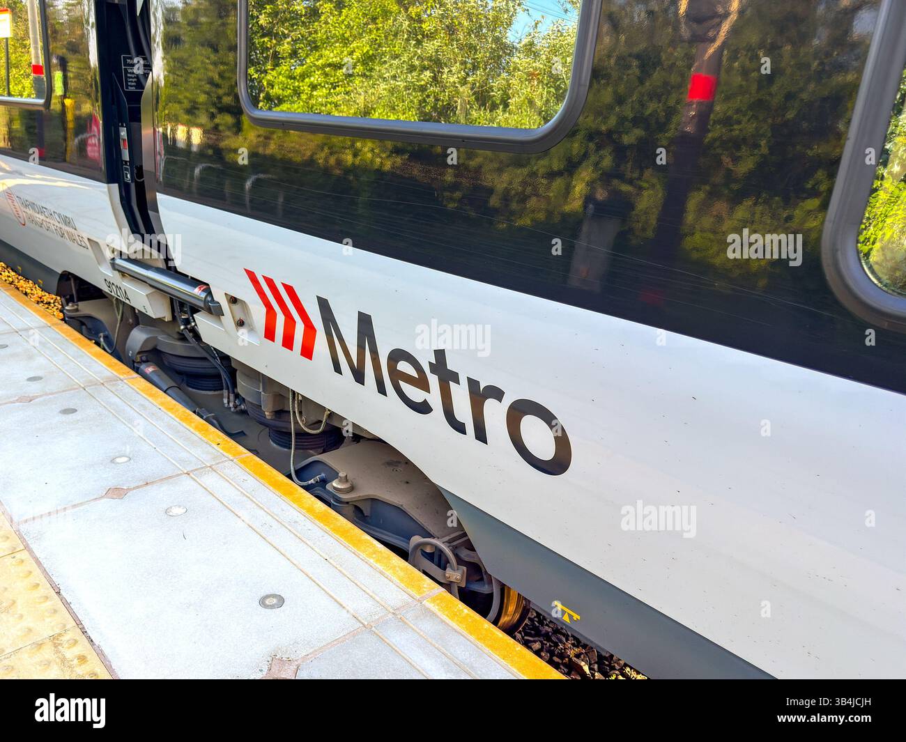 Treforest, Pontypridd, Wales, UK - 29 April 2025: Close up view of the South Wales Metro logo on the side of a Transport for Wales train - Smartphone Captured Stock Image