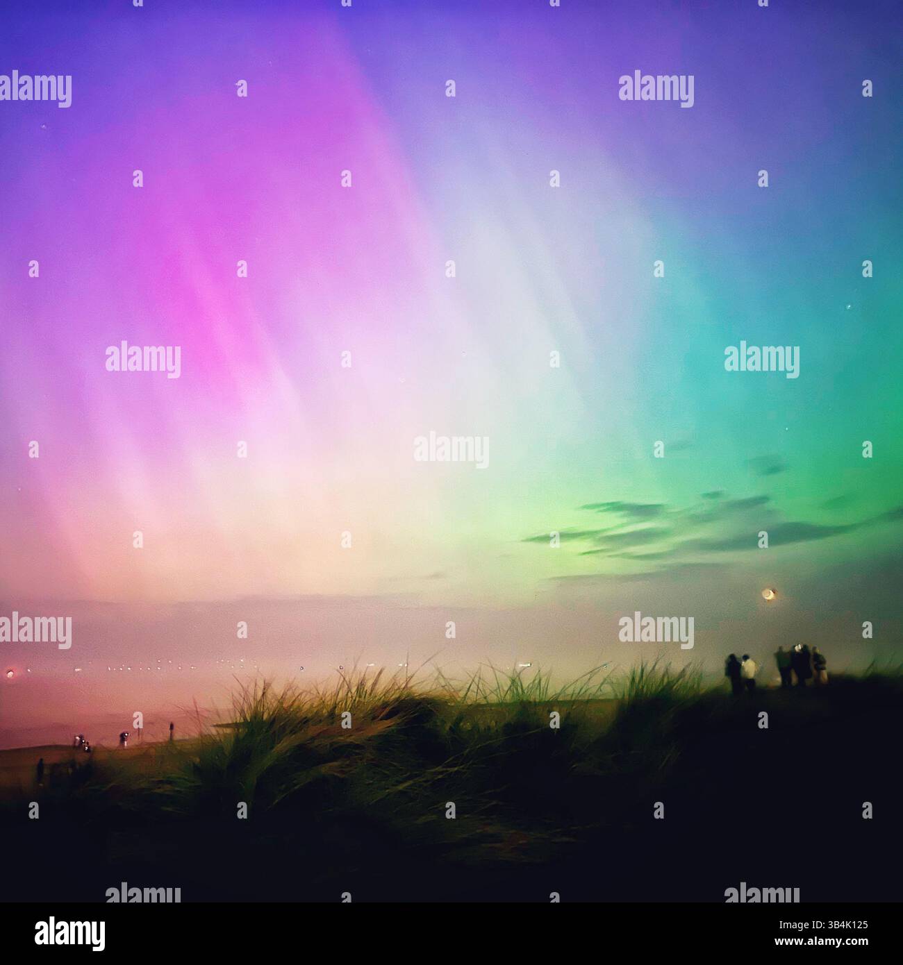 Vibrant green and purple aurora borealis (northern lights) in the night sky over Crosby Beach, England, during the rare geomagnetic storm of May 10 24 - Smartphone Captured Stock Image