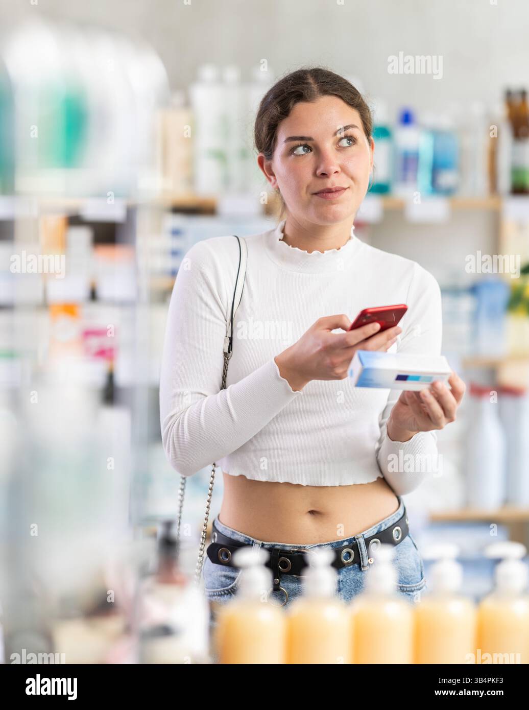 Woman scans code on package of ointment to check the expiration date ...