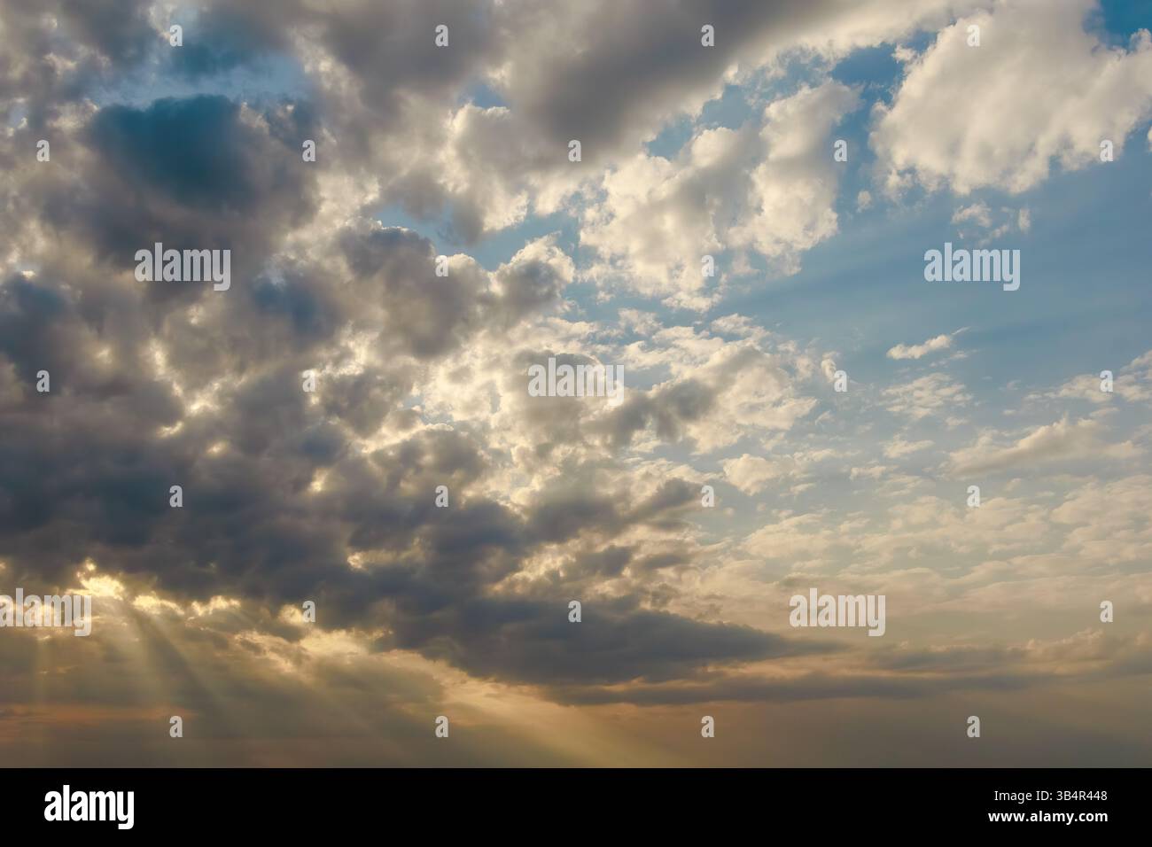 Naturally Dramatic Sunlight streams through a moody sky filled with dark and light clouds ...