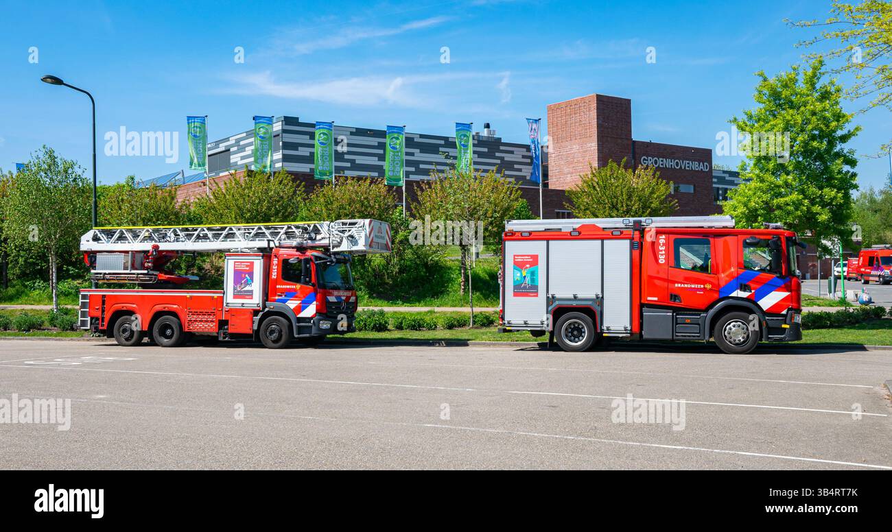 Red fire trucks are parked in a parking lot. Stock Photo