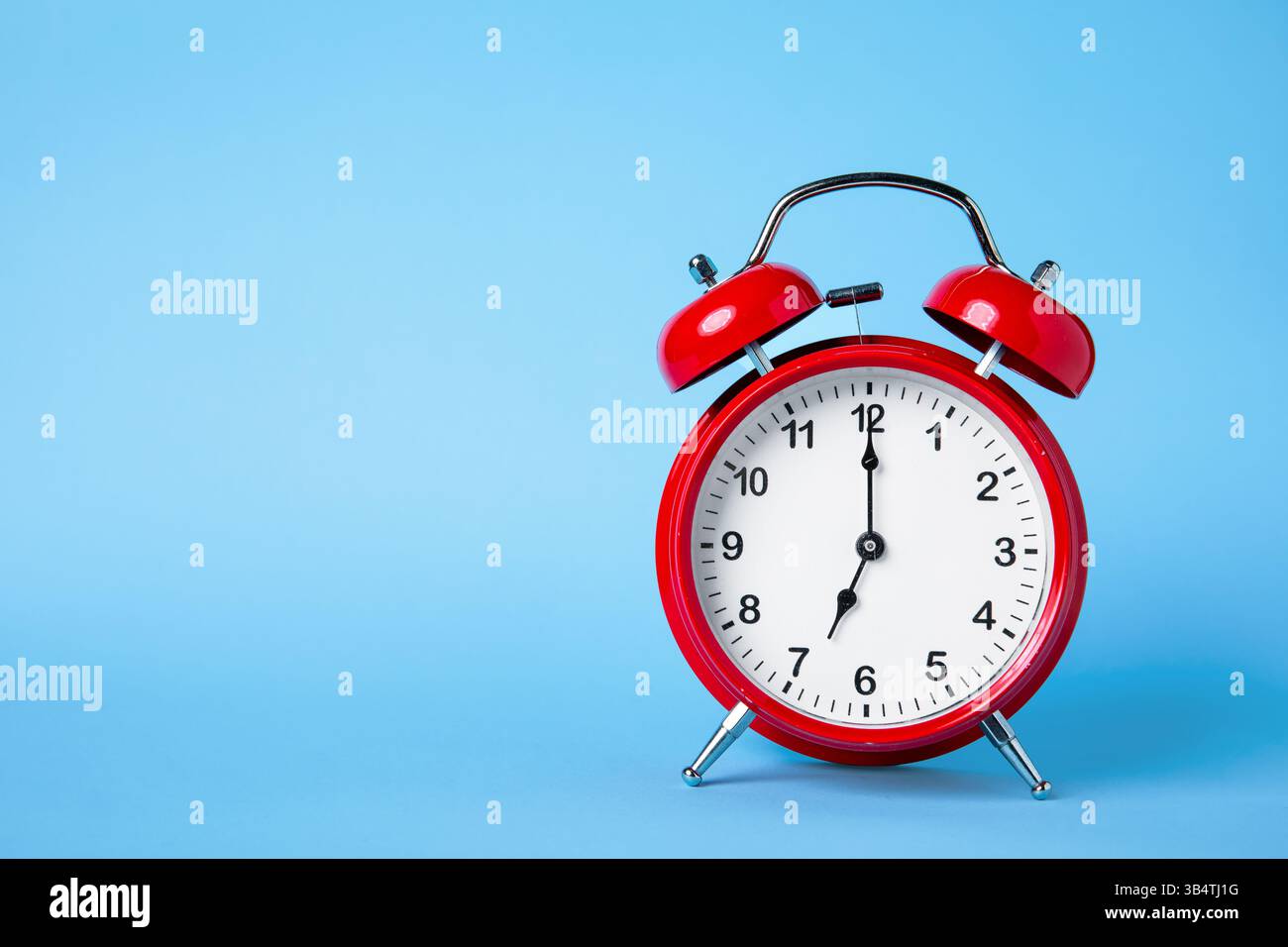 Classic Red Alarm Clock on Light Blue Background Stock Photo