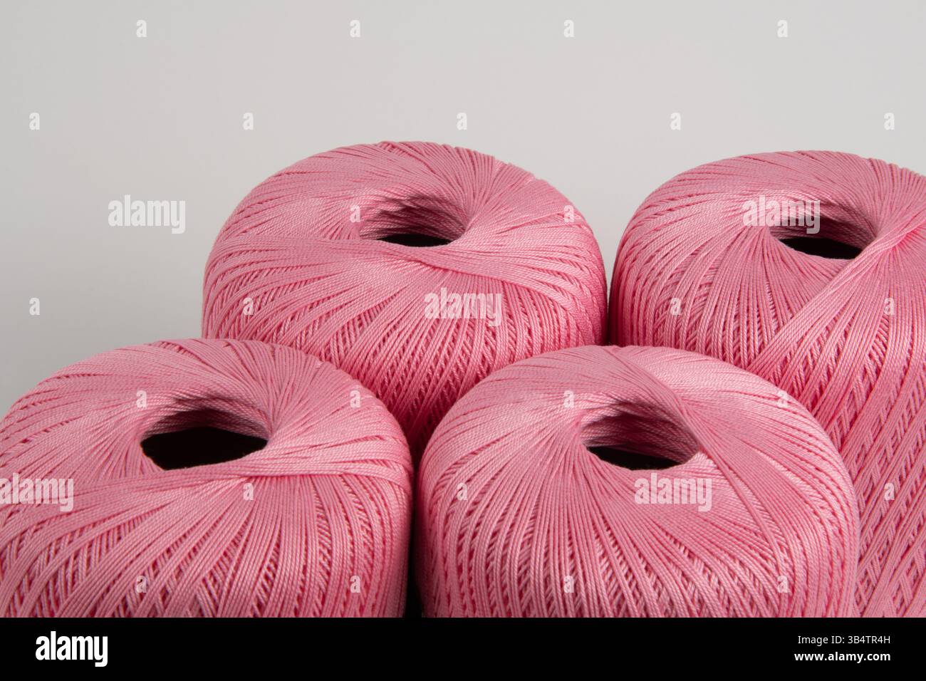 Spools of pink thread on a gray background. Photo for a banner. Stock Photo