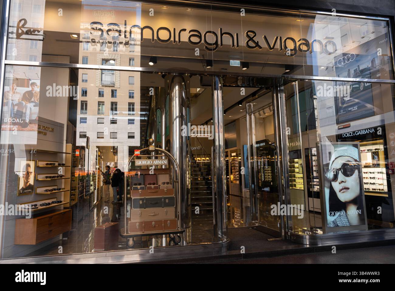 Milan, Italy - April, 08, 2025: Salmoiraghi and Vigano eyewear store exterior. Sunglass displays, Giorgio Armani poster, glass facade. Milan street Stock Photo