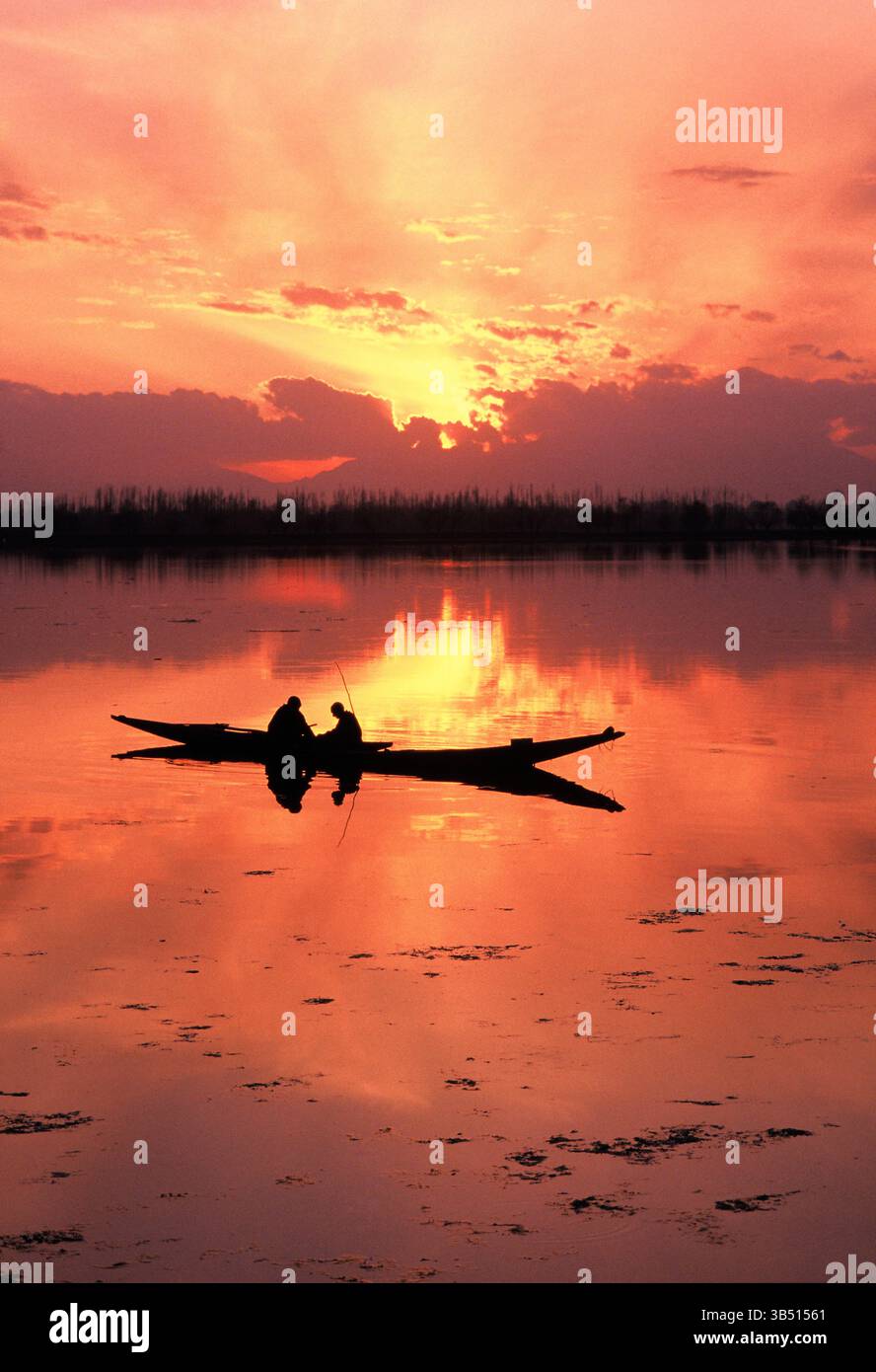 India. Jammu and Kashmir. Dal Lake at sunset with boat silhouette. Stock Photo