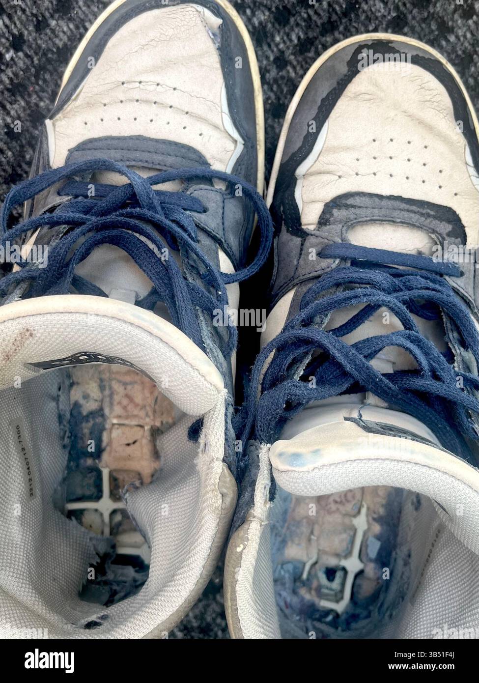 Old trainers with visible insole damage, showing signs of extended use and worn shoe interior - Smartphone Captured Stock Image