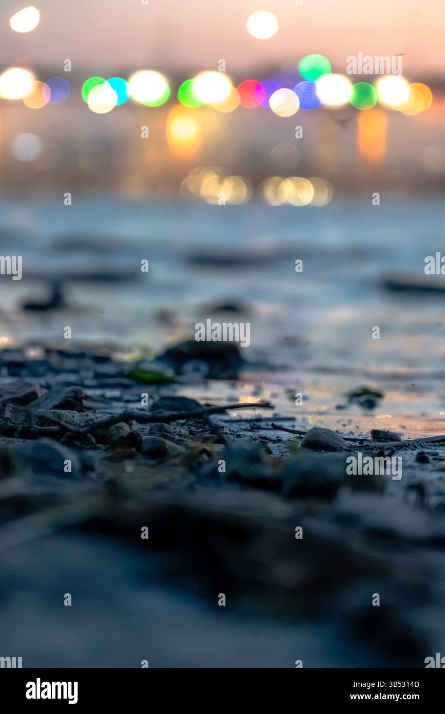 Colorful bokeh lights reflected on a riverbank surface Stock Photo