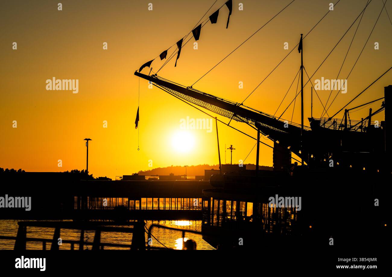 shipyard silhouette at sunset with flags Stock Photo - Alamy