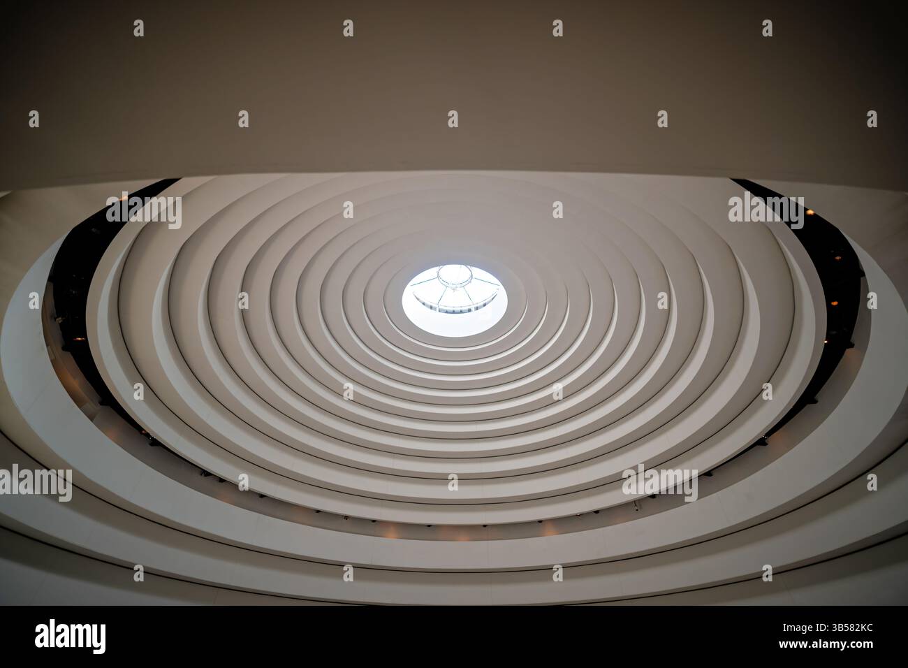 WASHINGTON DC — The distinctive dome above the main atrium of the National Museum of the American Indian features an elegant curved design that allows natural light to flood the central space. Designed by Blackfoot architect Douglas Cardinal, the dome incorporates indigenous design principles with its east-facing central oculus and organic, flowing forms. This prominent architectural feature crowns the museum's 120-foot-high central gathering space known as the Potomac, creating a dramatic focal point for visitors exploring one of the Smithsonian's most architecturally unique buildings. Stock Photo