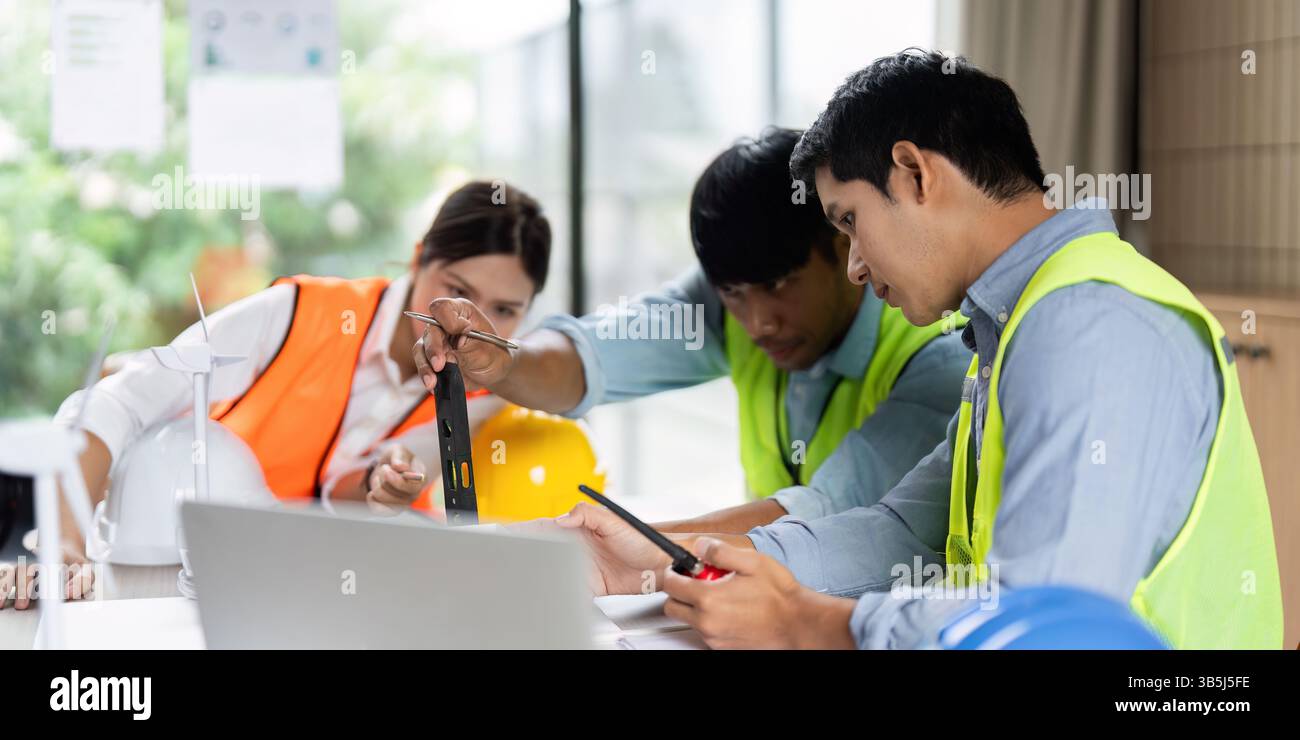 Green Tech and Engineering Collaboration. Engineers working on sustainable construction plans. Stock Photo