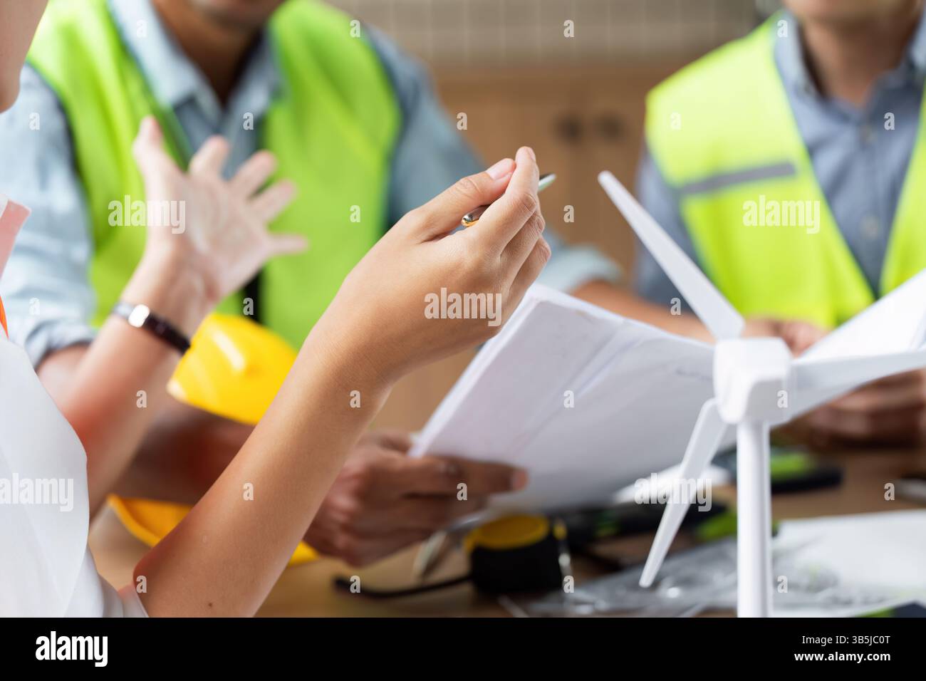 Green tech engineers brainstorming ideas for wind turbine projects Stock Photo