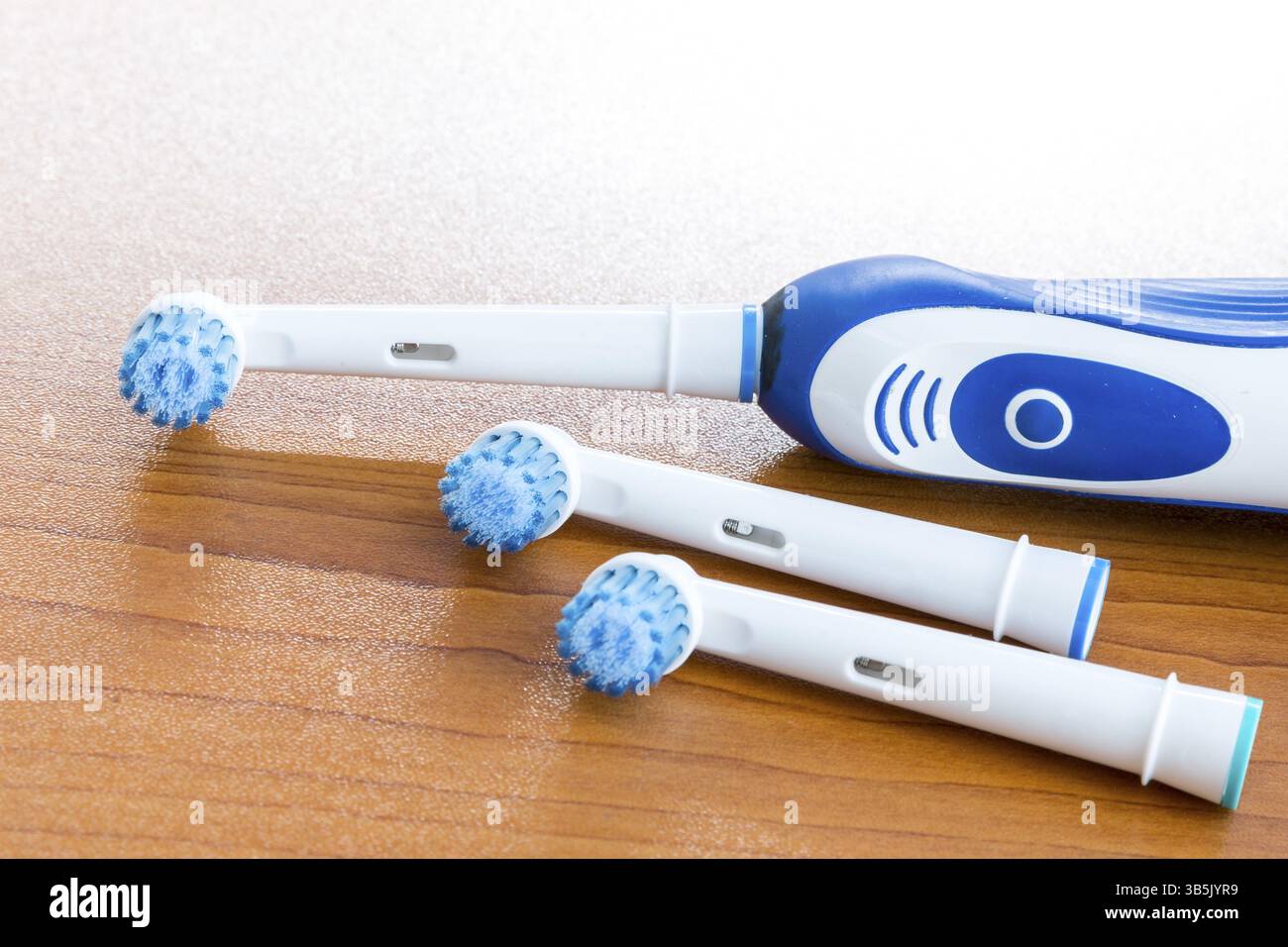 Electronic toothbrush with toothbrush heads on a table Stock Photo
