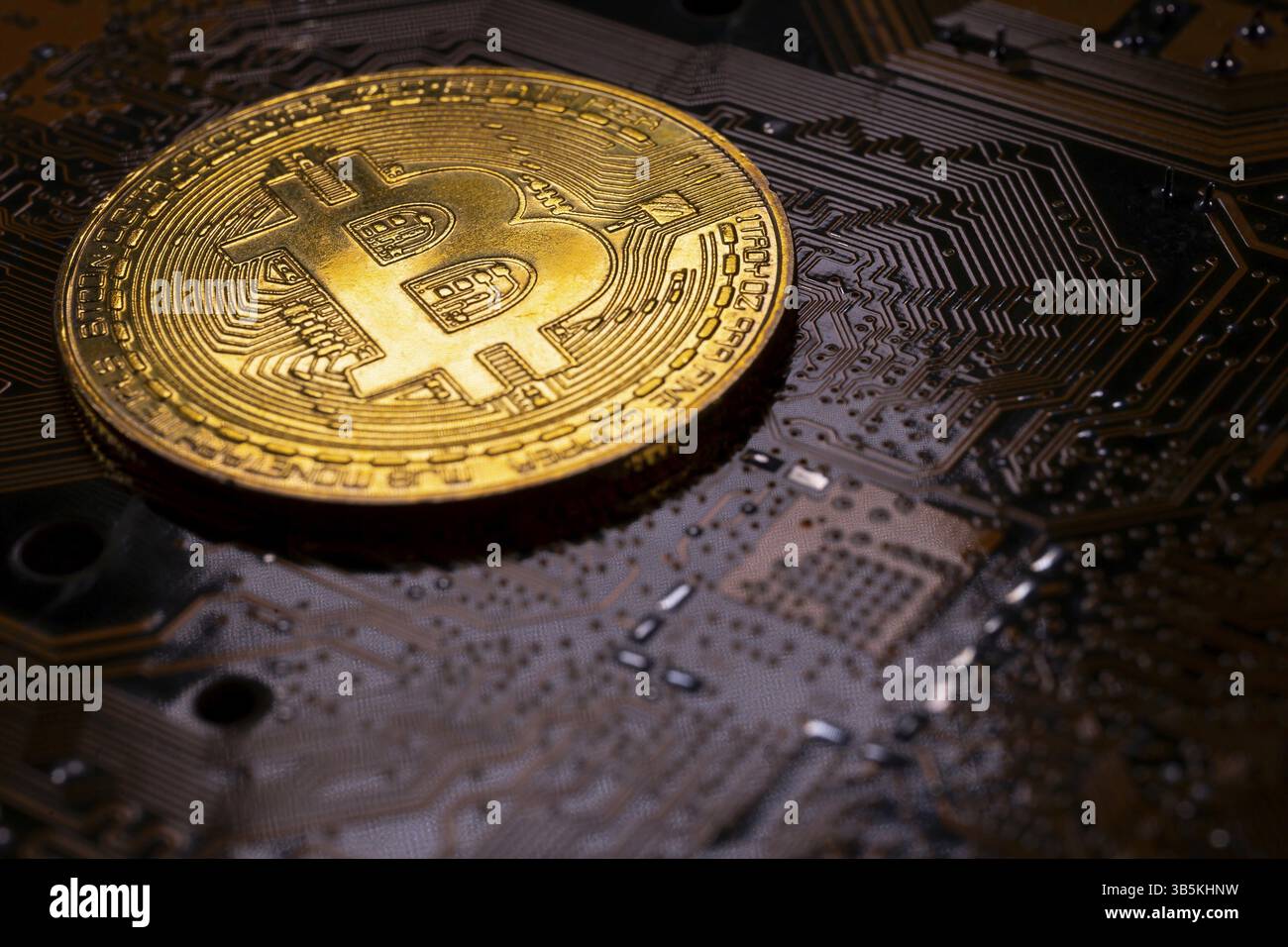 Virtual cryptocurrency money Bitcoin golden coin on a computer printed circuit board PCB. The future of money. Computational equipment. Dark image Stock Photo