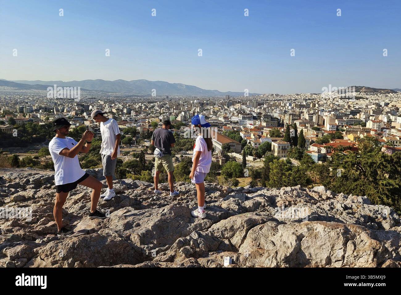 Athens, Greece - 1 June, 2024: People take pictures from a hill near the Acropolis in Athens, Greece, Europe Stock Photo