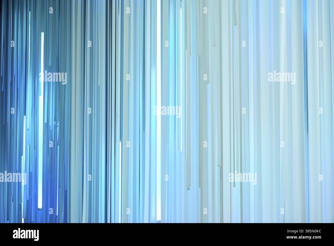 Light blue vertical stripes hanging and creating a modern abstract background Stock Photo