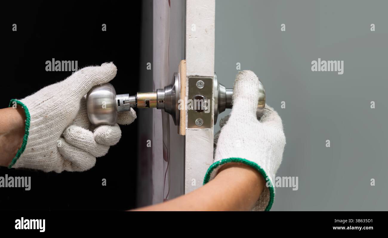 Locksmith repairing a broken door knob. Stock Photo