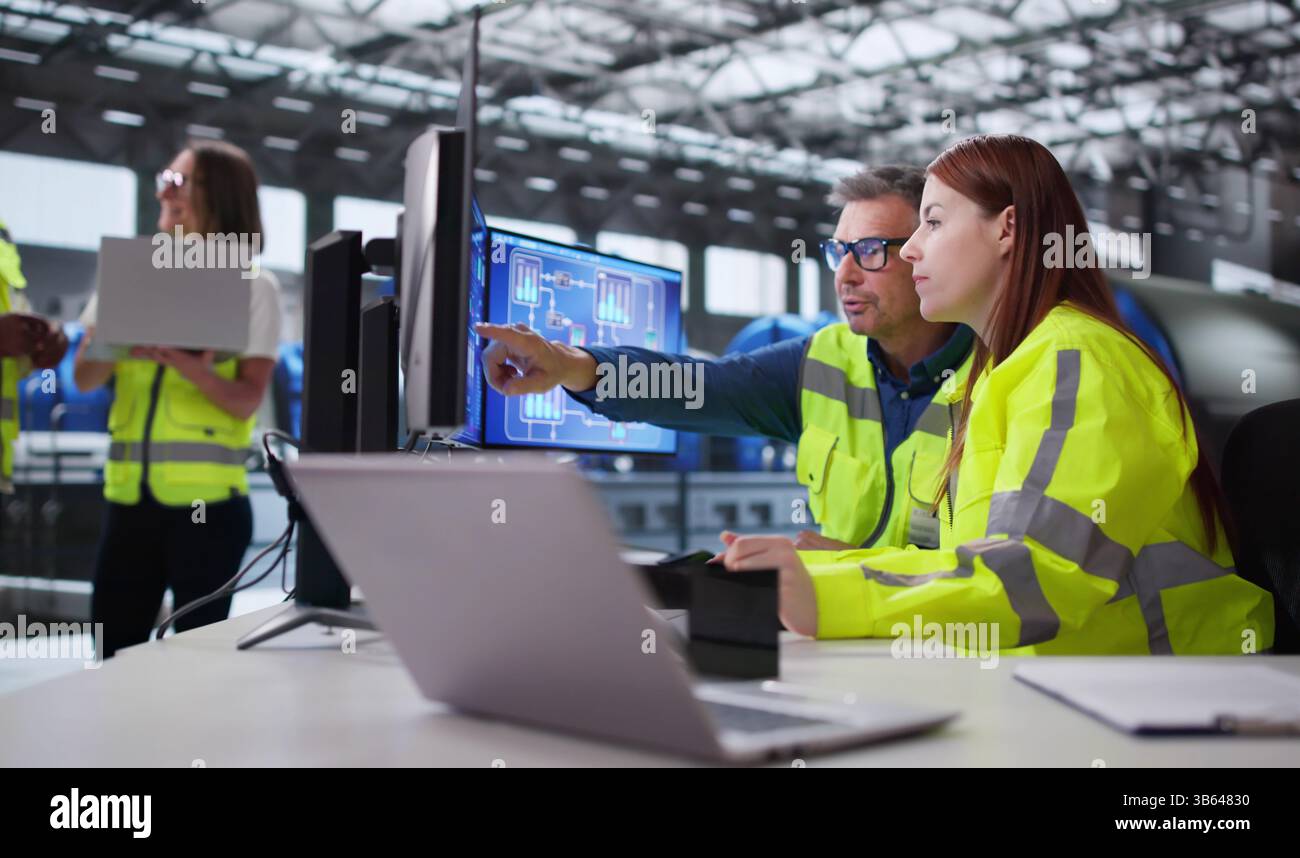 Engineer Operating Control Panel At Power Plant Generating Electricity For City. Stock Photo
