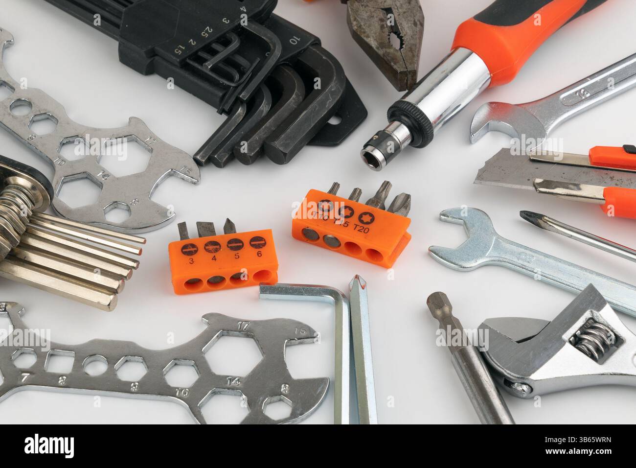 Assorted hand tools including wrenches, screwdrivers, pliers, hex keys on a white background. Stock Photo