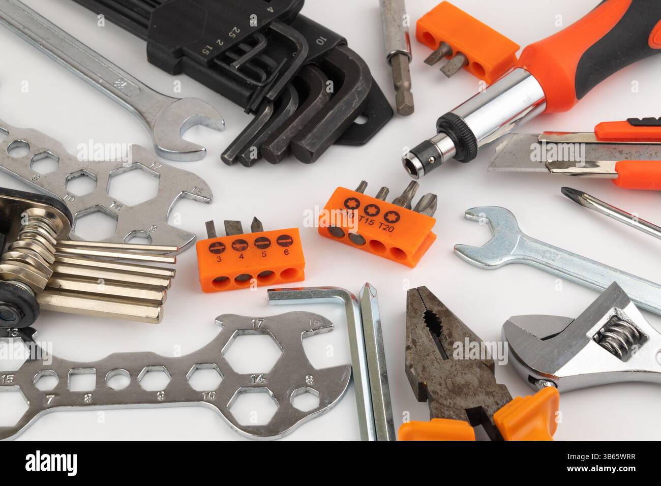 Assorted hand tools including wrenches, screwdrivers, pliers, hex keys on a white background. Stock Photo