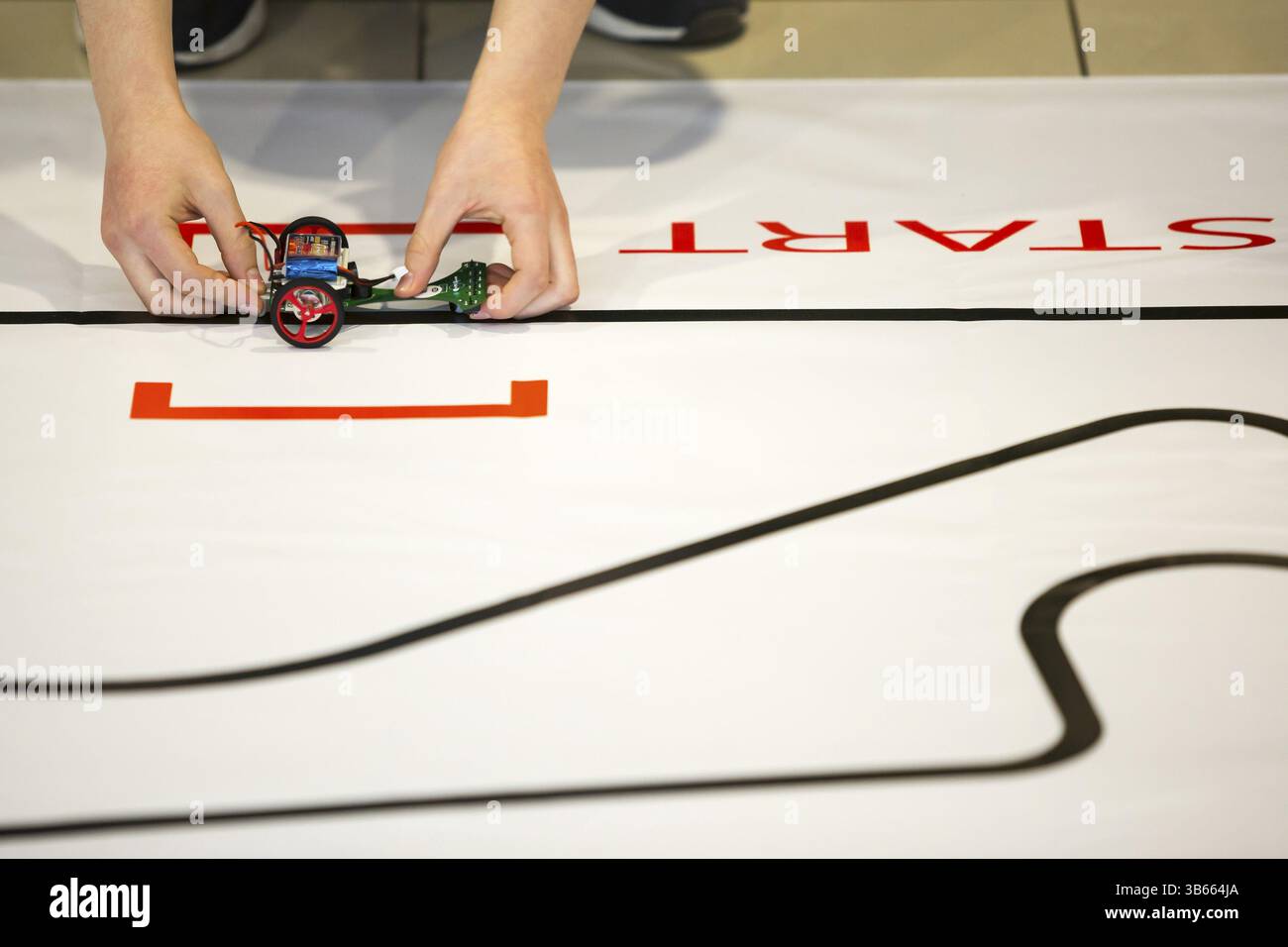 Sofia, Bulgaria - December 17, 2016: A student prepares his race robot during an open competition of self-made robots among school students Stock Photo