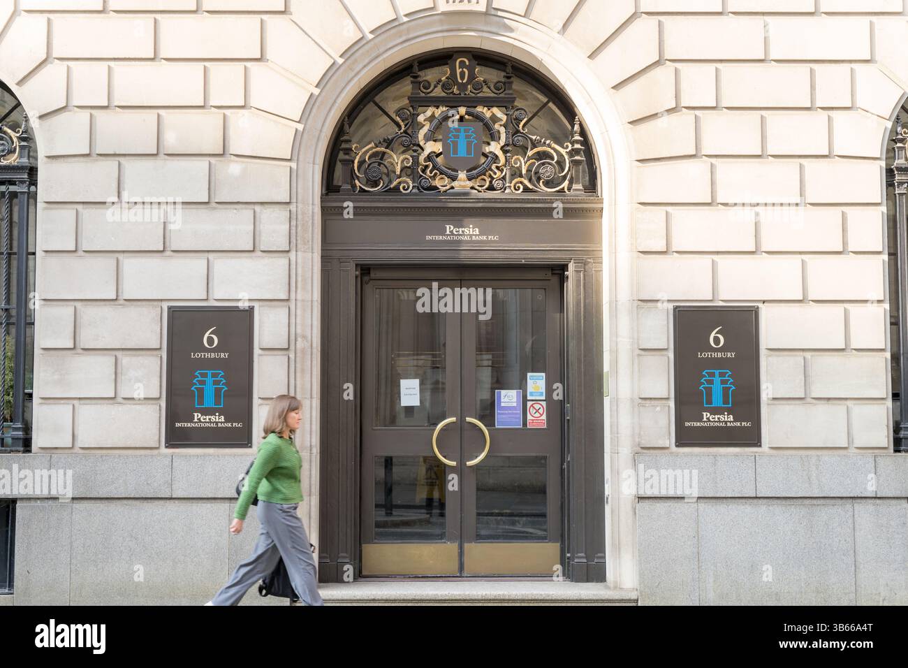 woman walk past the front door of Iranian Persia International Bank PLC , lothbury London Stock Photo