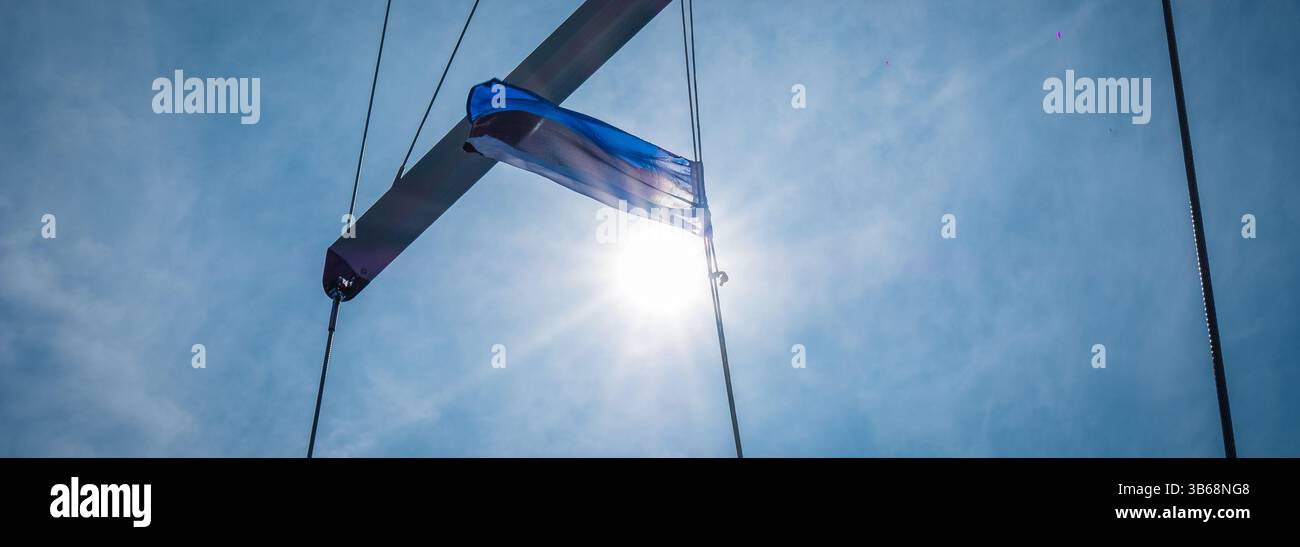 Estonian flag waving in wind and sunlight on a sailing boat. Flag of ...