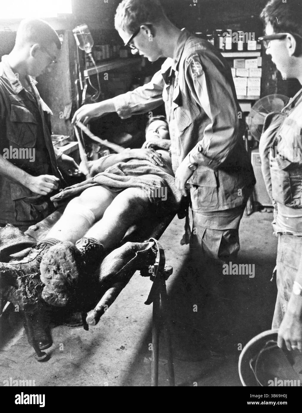 Special Forces doctors treat a wounded soldier at Ben Het Camp in South Vietnam, 1969. Stock Photo