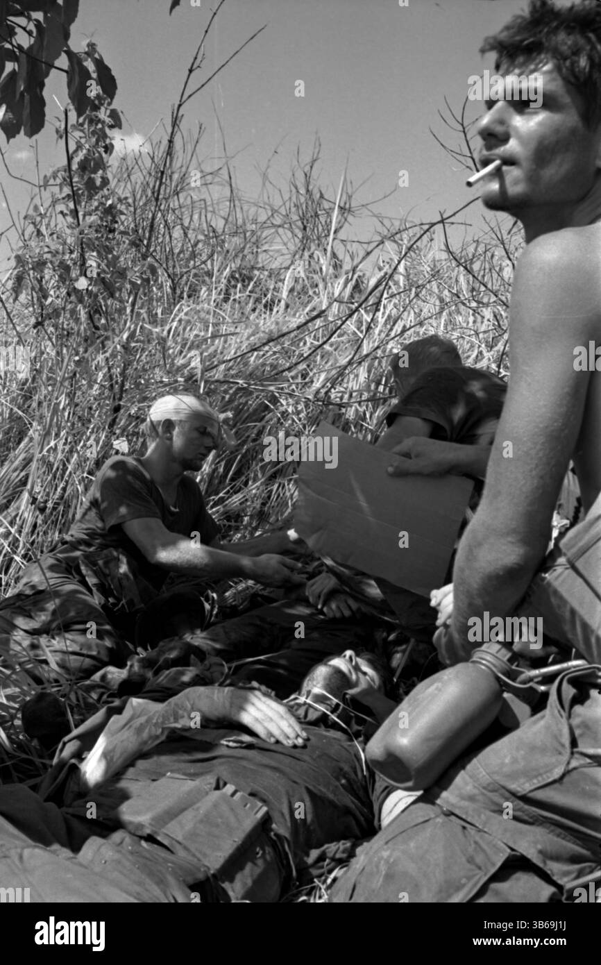 Soldier fans a mortally wounded comrade in the Hiep Duc Valley during the Vietnam War, 1969. Stock Photo
