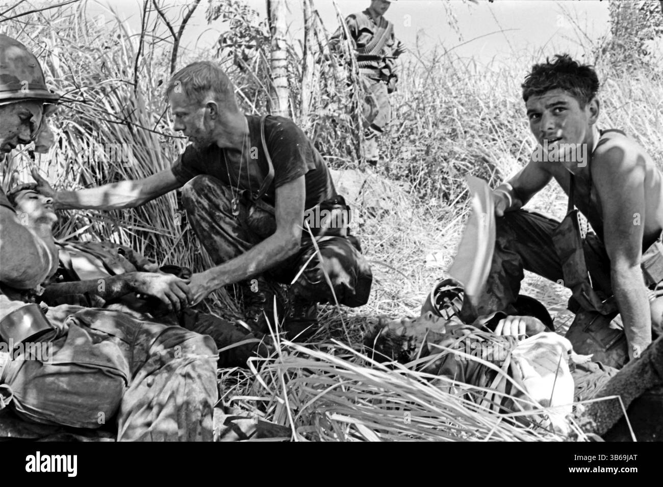 Wounded soldiers are comforted by their comrades in the Hiep Duc Valley during the Vietnam War, 1969. Stock Photo